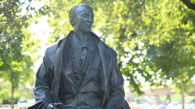 Statue von Karl Arnold in Düsseldorf mit Bäumen im Hintergrund